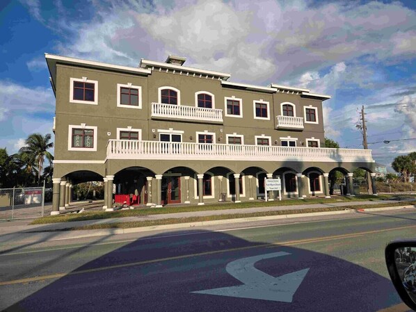 A two-story building with a balcony and arched entrance.