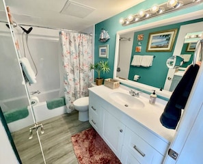 Ein Badezimmer mit Dusche, Toilette, Waschbecken und Waschtisch.