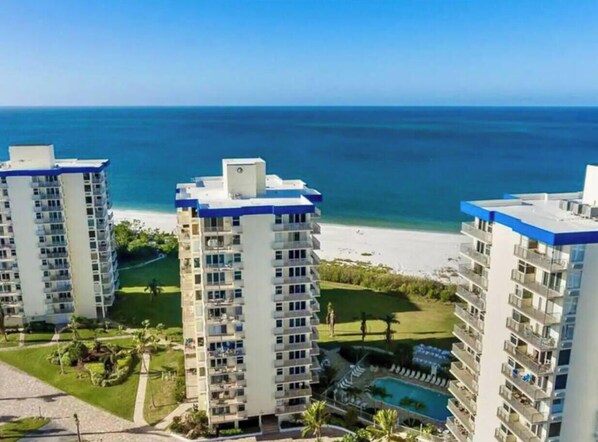 A high-rise hotel with multiple balconies overlooking a beach and ocean. - Sunset & Ocean Front Views-FM-Beach(Pool is Open) (Fort Myers Beach)