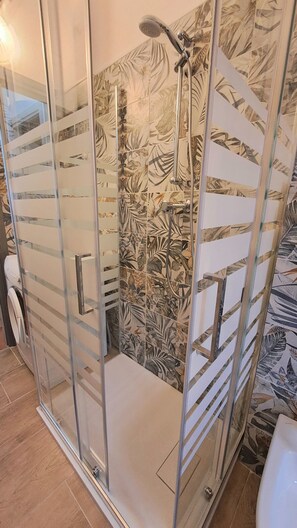 Enjoy a refreshing shower experience with a handheld and rain showerhead in this stylish bathroom.