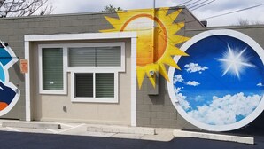 A building with a large mural of a sun and clouds on the side. - Charming studio in enchanting Colorado Springs with WiFi, AC (Colorado Springs)