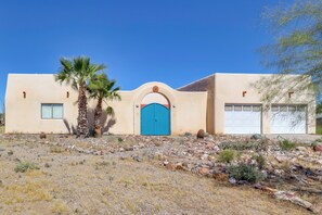 A building with a blue door, a garage, and a palm tree. - Desert Retreat in Golden Valley: Courtyard & Views (Golden Valley)