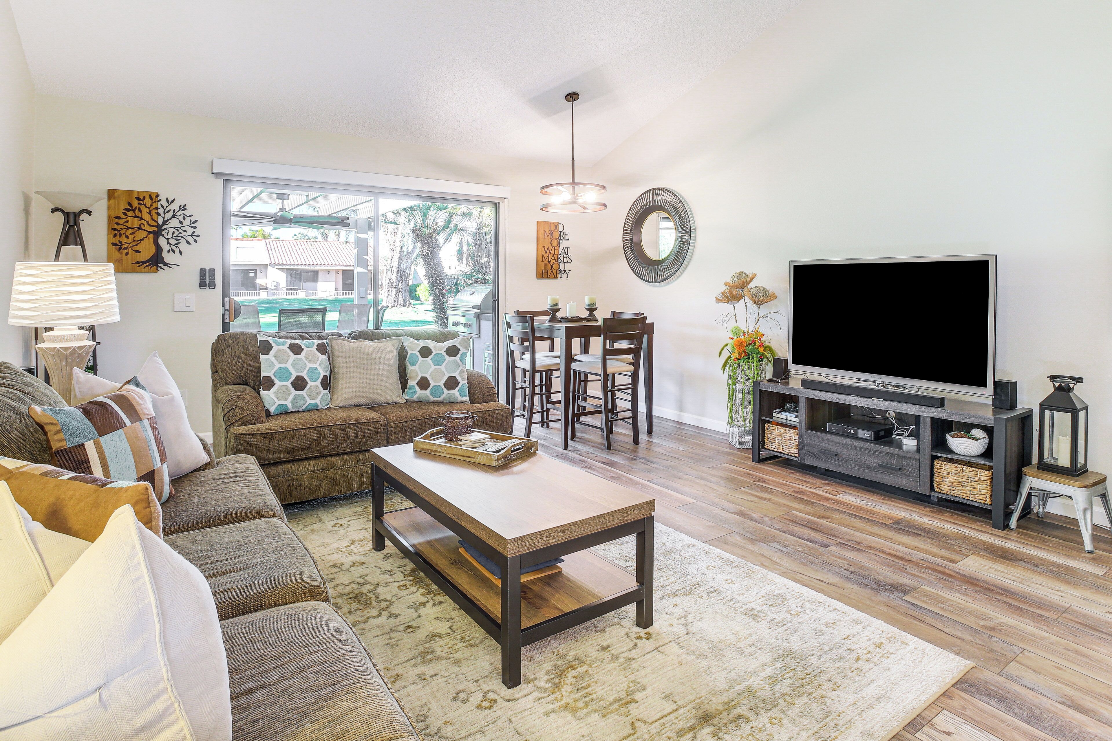 A living room with a sofa, coffee table, TV, and dining area.
