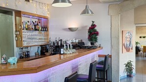 A bar area with a wooden counter, bar stools, pendant lights, and a wall-mounted air conditioner. - O'Fun Art  (Airvault)