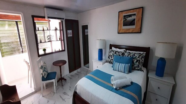 Une chambre à coucher avec un lit, des tables de chevet, une chaise et une petite table.