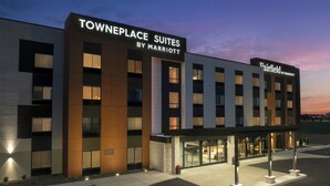 Un moderno edificio de hotel con un letrero que dice "TOWNPLACE SUITES BY MARRIOTT" y "Fairfield BY MARRIOTT".