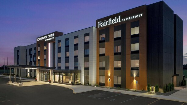 Ein Hotel Fairfield by Marriott mit modernem Design, das ein gut sichtbares Schild, einen überdachten Eingang und einen Parkplatz zeigt.