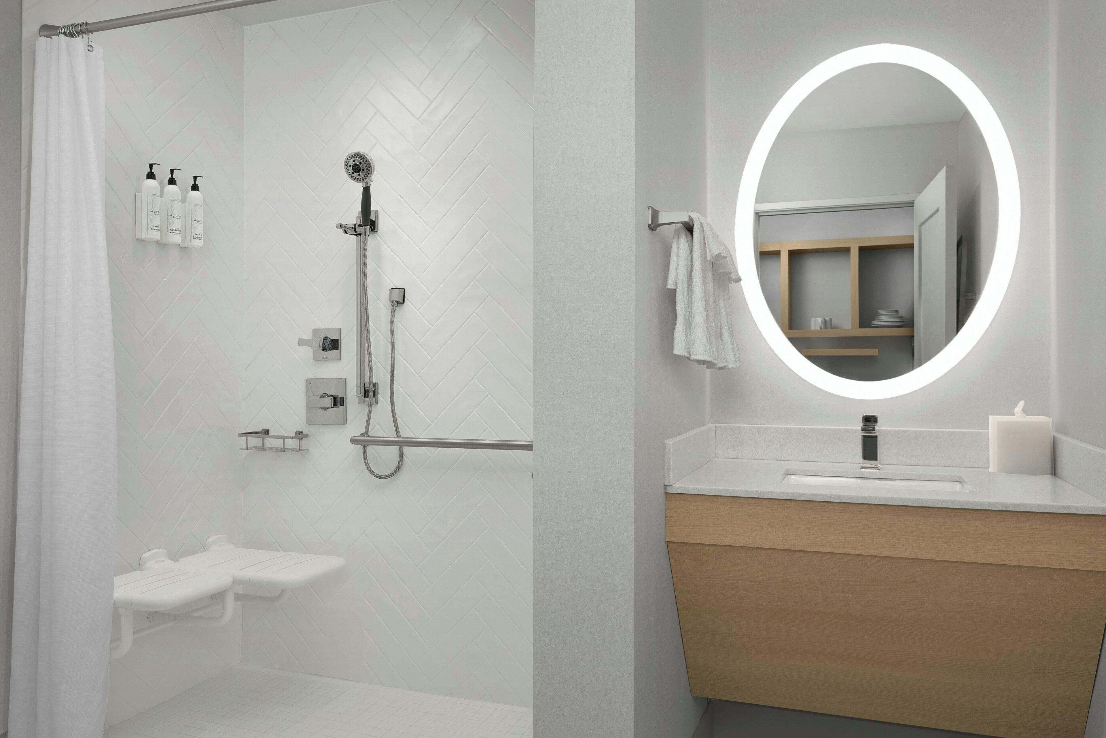 Een moderne badkamer met douche, toilet en wastafel met spiegel.