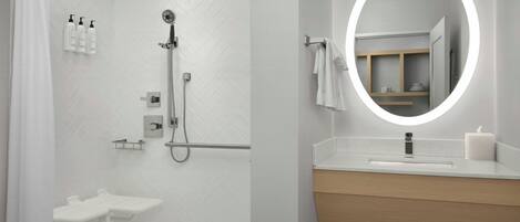 Een moderne badkamer met douche, toilet en wastafel met spiegel.