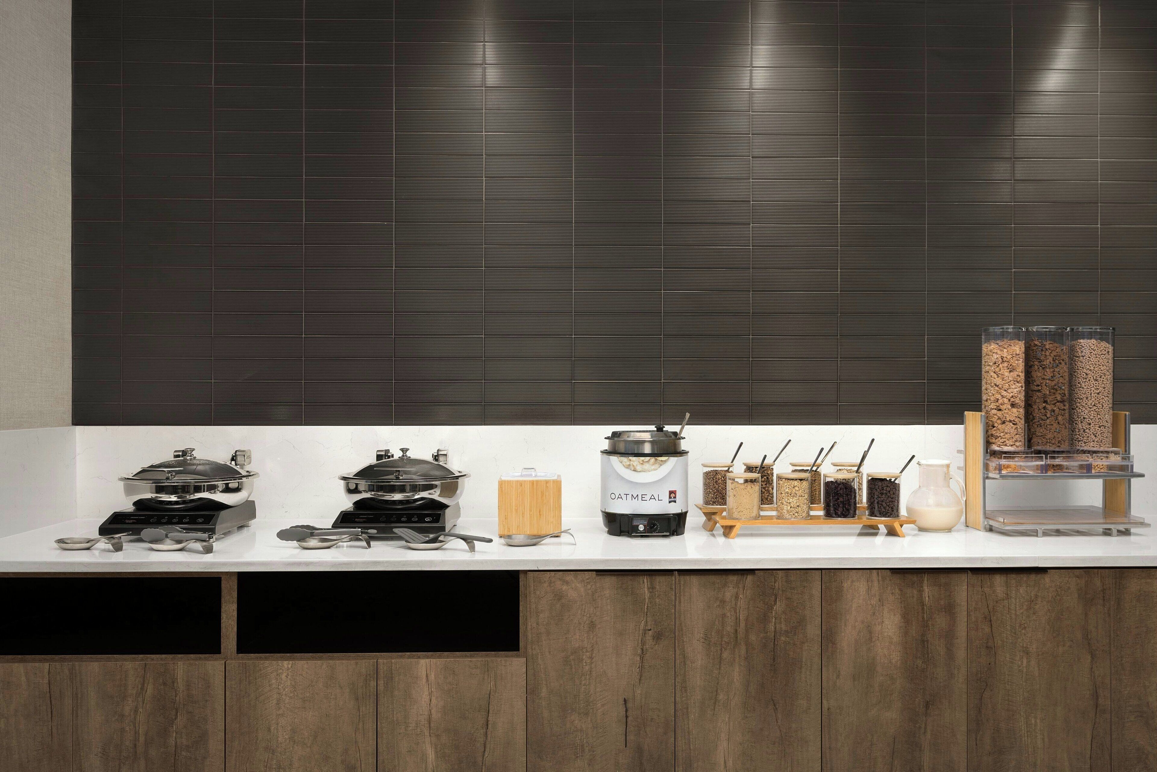 A kitchen counter with cooking appliances, a coffee maker, and various food containers.