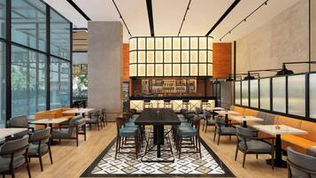A modern restaurant with a central bar, high ceilings, and large windows.