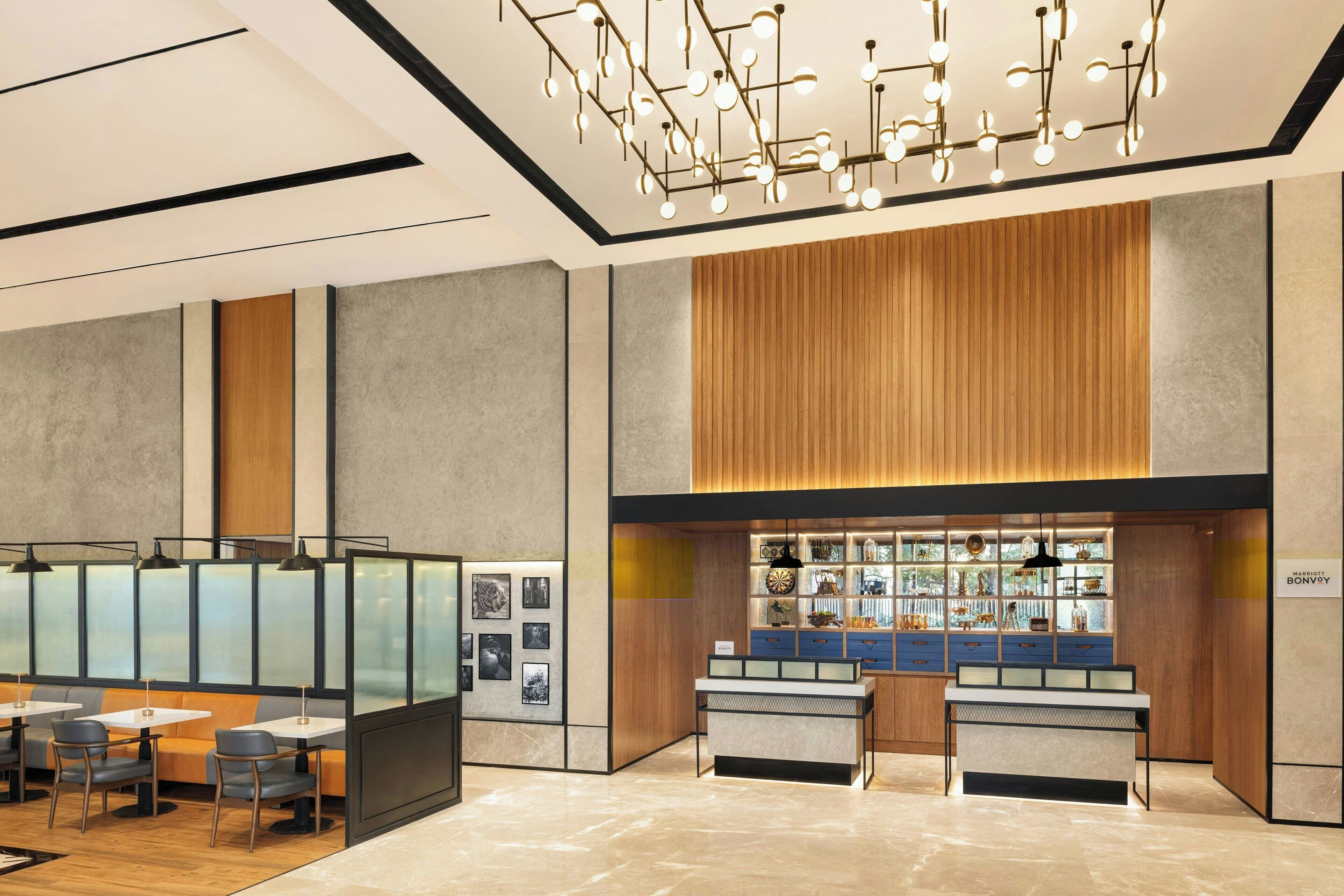 A modern hotel lobby with a reception desk, seating area, and a display of local crafts.
