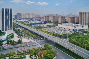 Un área urbana moderna con edificios altos, una autopista y comercios, incluyendo una gran tienda IKEA.