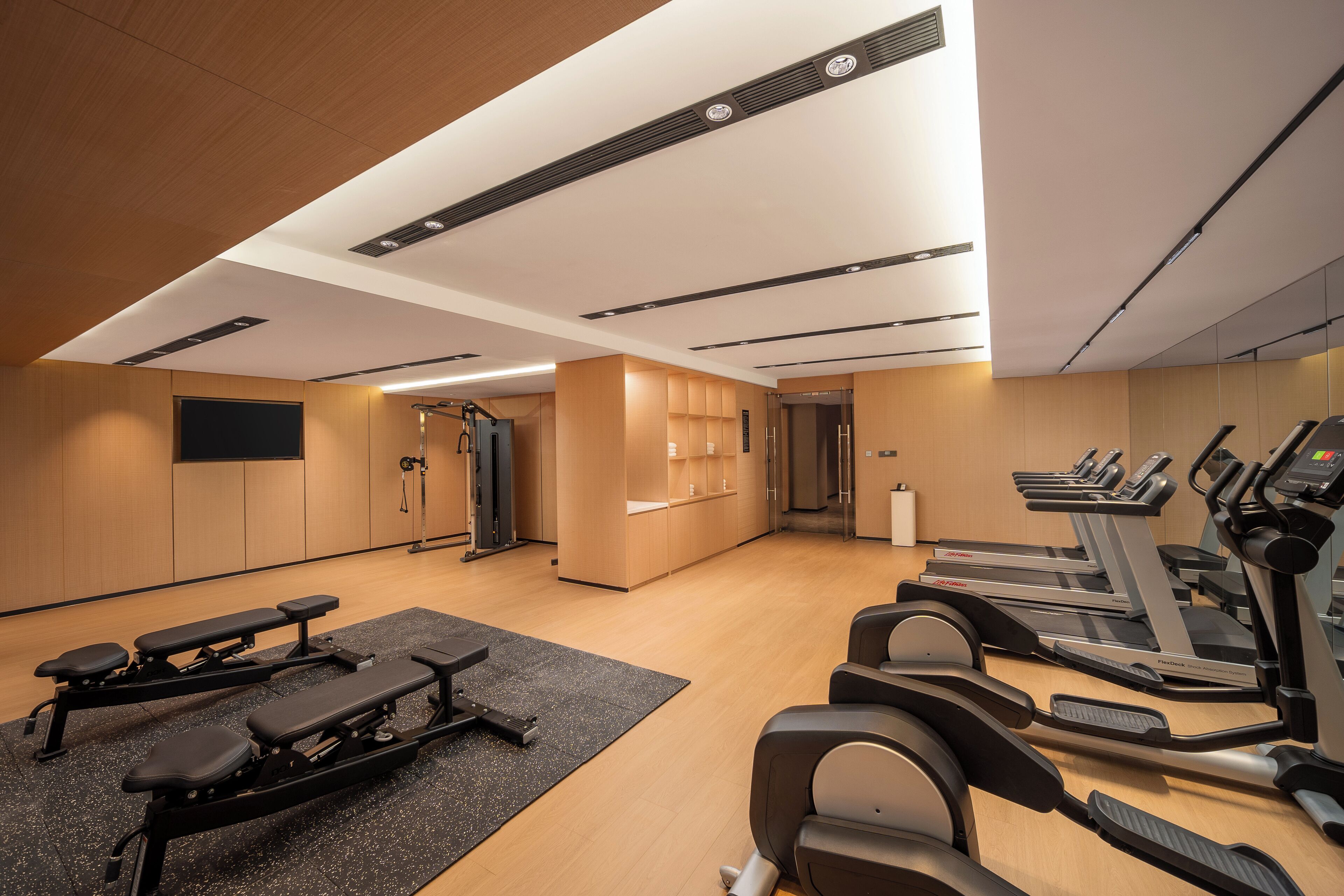A modern gym with treadmills, a bench press, and weight machines.