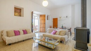 A spacious living room with two sofas, a glass coffee table, and a fireplace. - Beach front home in Ibiza (Ibiza)