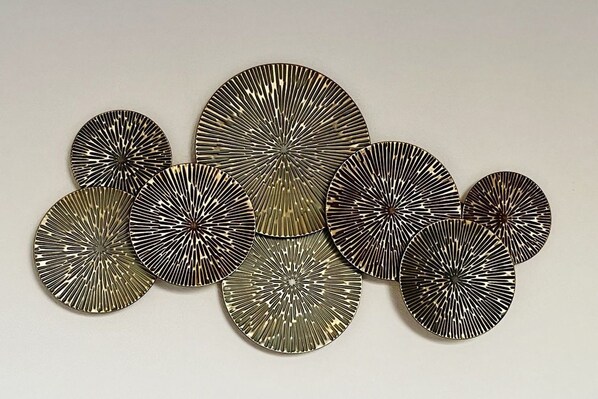 A collection of circular metal wall art pieces with radial patterns.