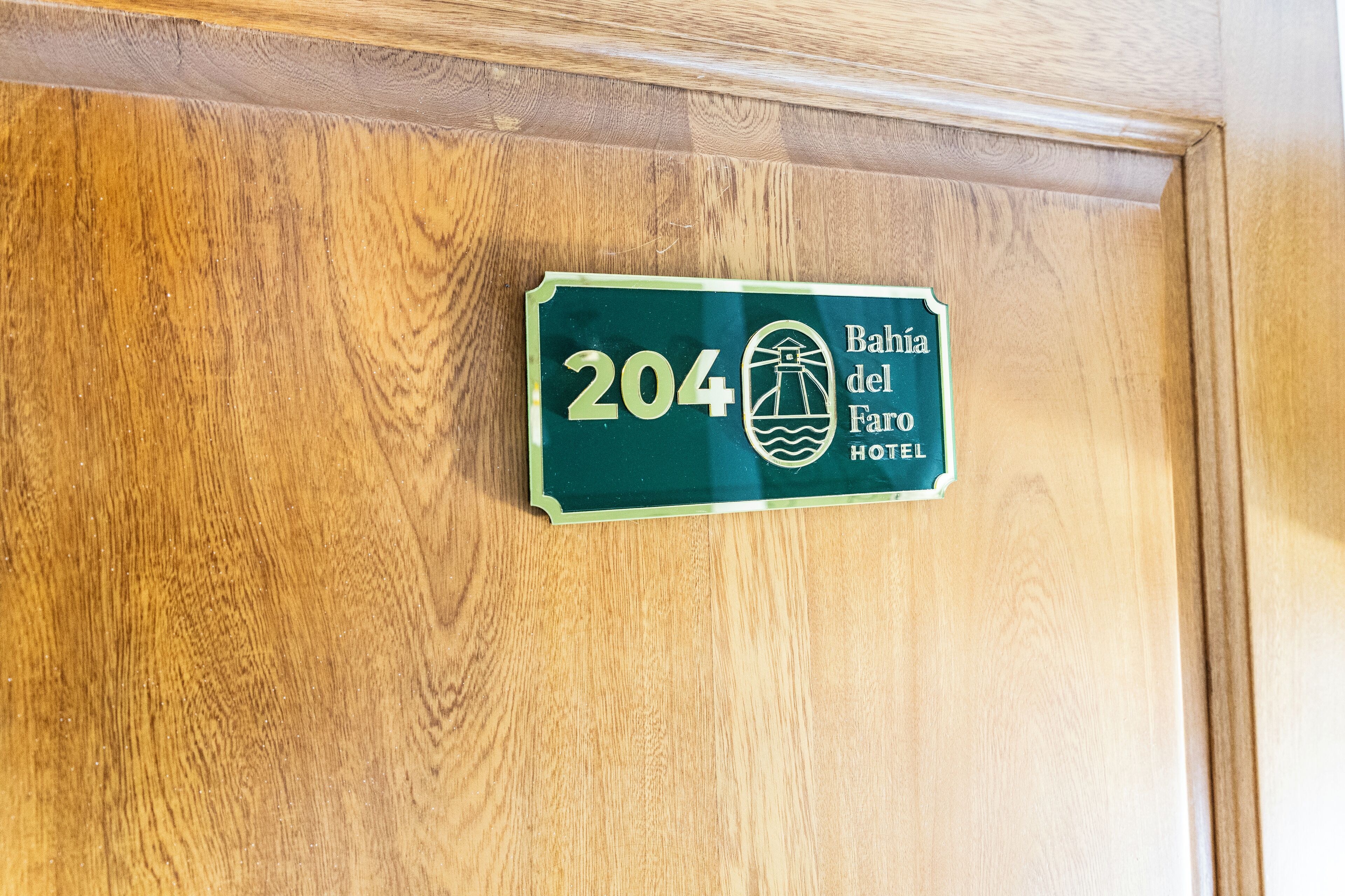 A wooden door with a hotel room number sign.