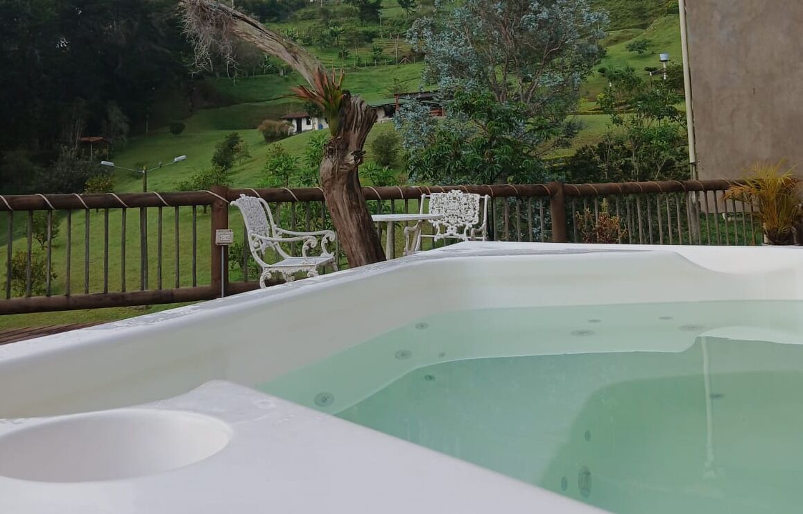 A hot tub with a view of a green landscape.