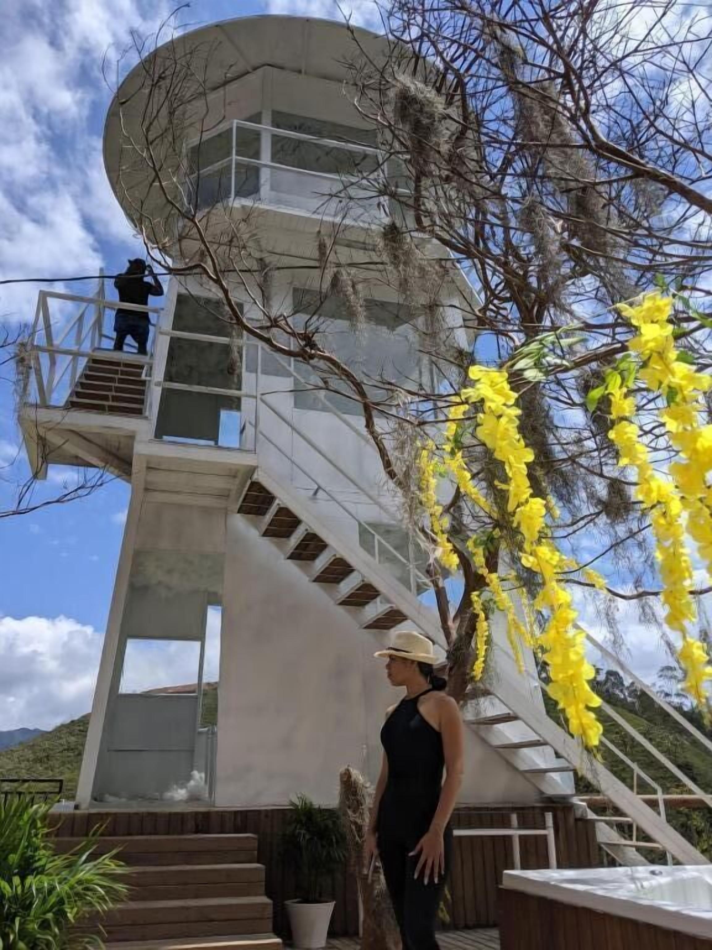 Un edificio moderno con una escalera de caracol, una bañera de hidromasaje y vistas del paisaje circundante.