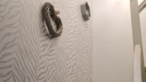 A staircase with a zebra-striped wall, a decorative wall hanging, and a blue handrail. - Entire house 🏠.  suitable for families and workers.  (Middlesbrough)