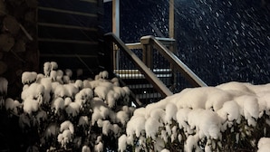 Schneebedecktes Freigelände mit einer Treppe, die zu einem Gebäude führt.