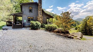 Eine rustikale Holzhütte mit Steinofen und Kiesweg.