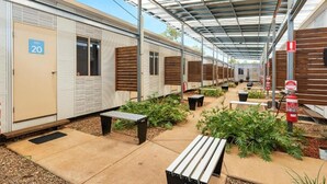 A row of portable cabins with a covered walkway, outdoor seating, and fire extinguishers. - Discovery Parks - Cloncurry (Cloncurry)