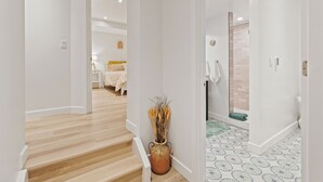 A hallway with a wooden staircase, a potted plant, and a bathroom with patterned tiles. - 2BR Apt + Sauna in Earth House, Minutes to Boulder (Superior)