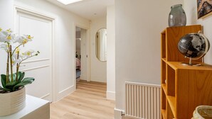 Een gang met dakraam, een potorkidee, een wereldbol op een houten plank en een radiator.