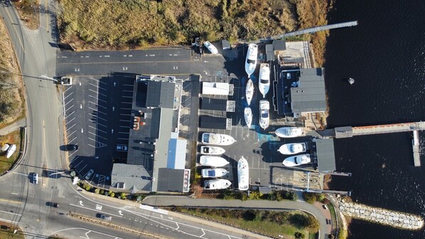 An aerial view of a marina with boats docked, a road with directional arrows, and a bridge over water. - Guest House Suites (Salisbury)