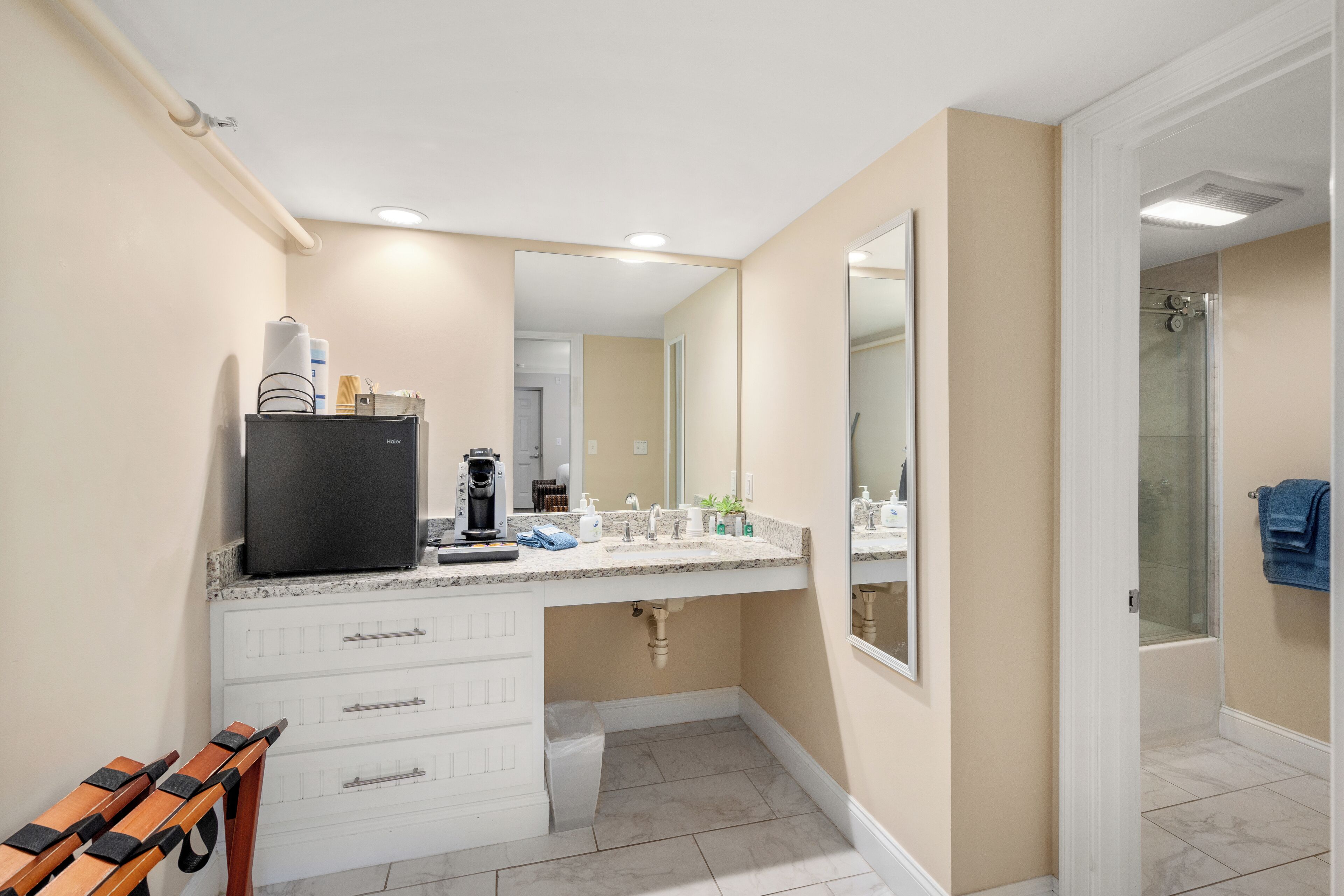 Un baño moderno con tocador, lavamanos y ducha.