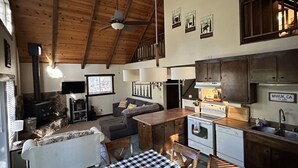 A cozy cabin interior with a dining area, kitchen, and living space.