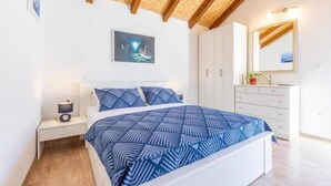 A bedroom with a bed, a nightstand, a dresser, and a mirror. - Amazing home in Dracevica (Dracevica)