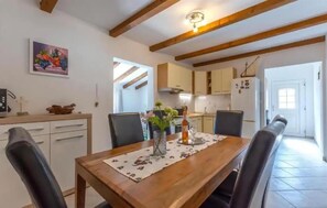 Enjoy meals and gatherings in this inviting dining area with a wooden table and comfortable seating for four.