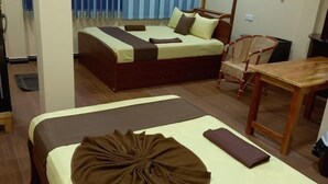 Una habitación de hotel con dos camas, una mesa de comedor y una silla.