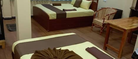 Una habitación de hotel con dos camas, una mesa de comedor y una silla.