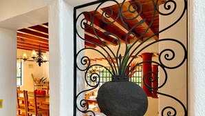 A black vase with a plant on a wooden shelf, surrounded by ornate metalwork. - Sandunga Lago Tzintzuntzan (Tzintzuntzan)