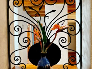 Un cadre métallique décoratif contenant un vase avec des fleurs.