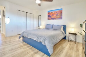 A bedroom with a bed, a nightstand, a lamp, a painting, and a wardrobe. - Modern retreat with games room in central location! (Page)