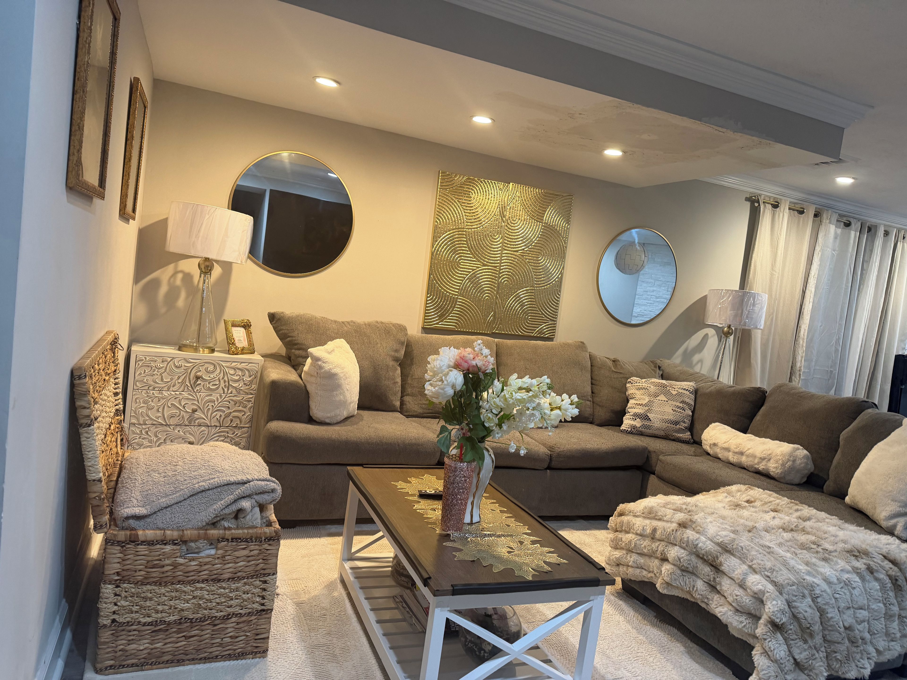 A living room with a sofa, armchair, coffee table, and decorative items.