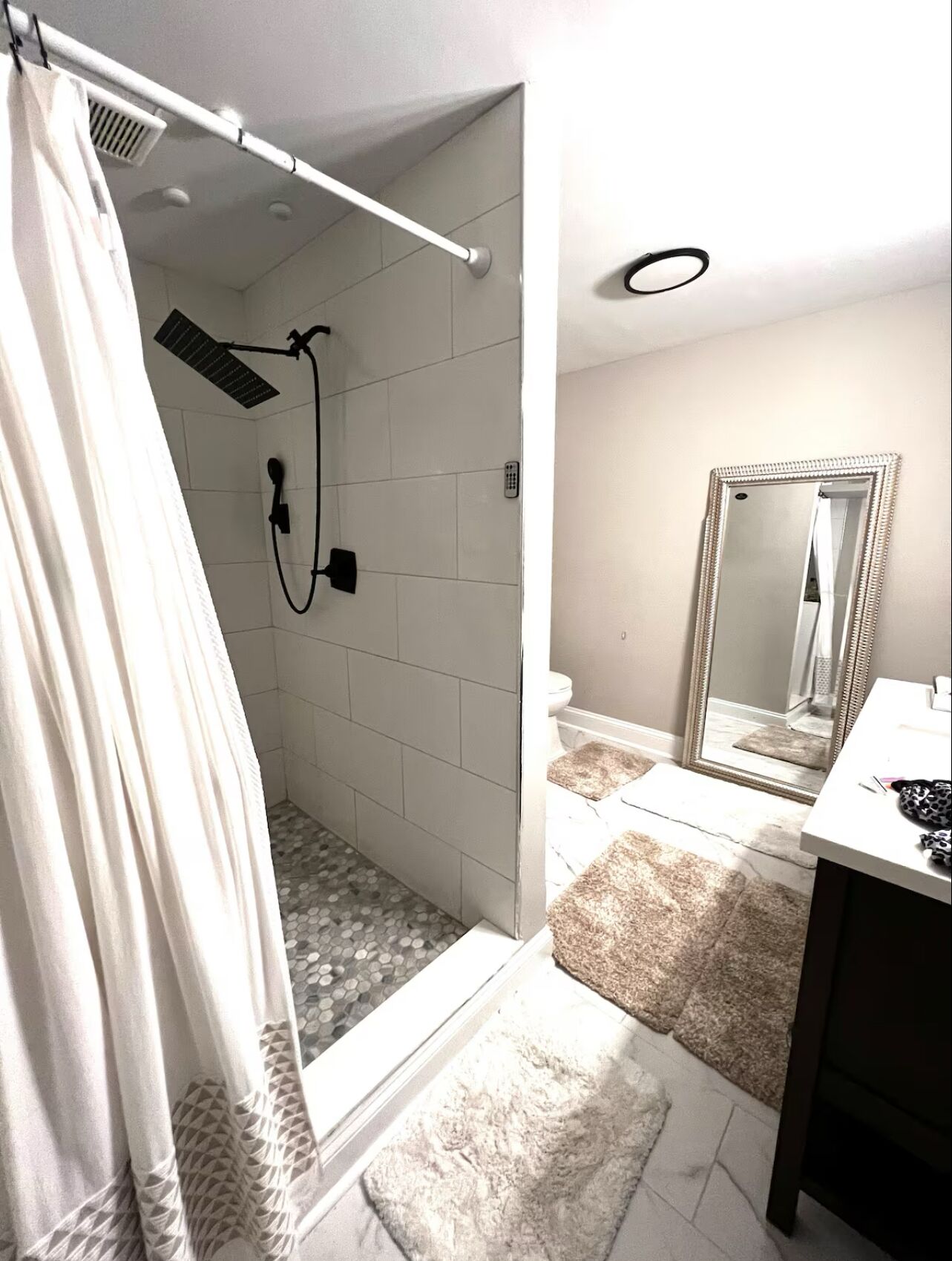 Ein Badezimmer mit Dusche, Toilette und Waschtisch.