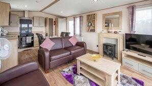 A compact living space with a kitchenette, a sofa, a TV, and a fireplace. - 2 bedroom accommodation in Retford (Retford)