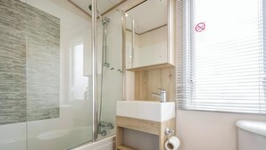 A modern bathroom with a glass-enclosed shower, a wooden vanity with a sink, and a toilet. - 2 bedroom accommodation in Retford (Retford)