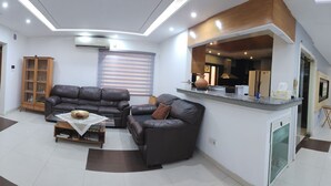 Una sala moderna con un conjunto de sofás, una mesa de comedor y una zona de cocina.