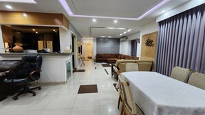 Una sala de estar moderna con comedor, sofá, mesa de centro y televisor.