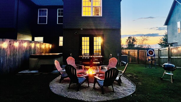 A two-story house with a fire pit in the backyard, surrounded by outdoor seating. - NEW~9 min to Dollywood~Hot Tub~Arcade~4 Bedroom (Sevierville)