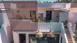 Een modern huis met een zwembad, terras en een trap.