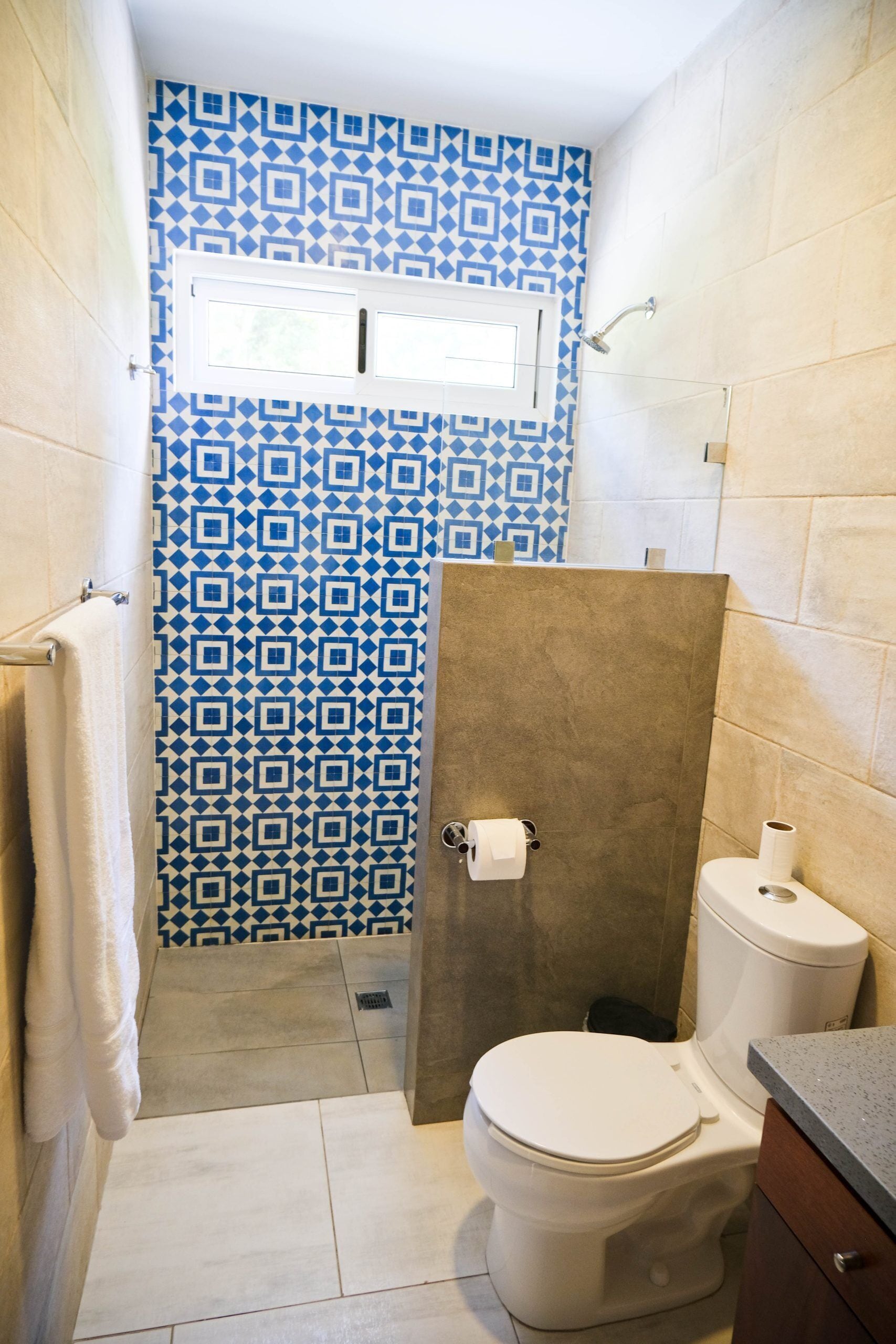 A bathroom with a patterned shower curtain, a toilet, and a sink.