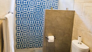 A bathroom with a patterned shower curtain, a toilet, and a sink.