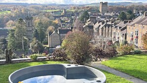 A hot tub with a view of a town and castle in the background.